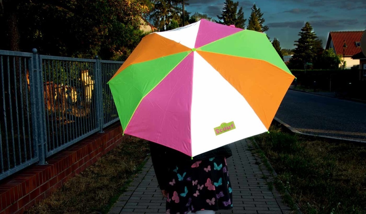 Mit einem regenbogenbunten Kinderschirm im Ranzen sind Schulkinder doppelt geschützt Foto: Scout