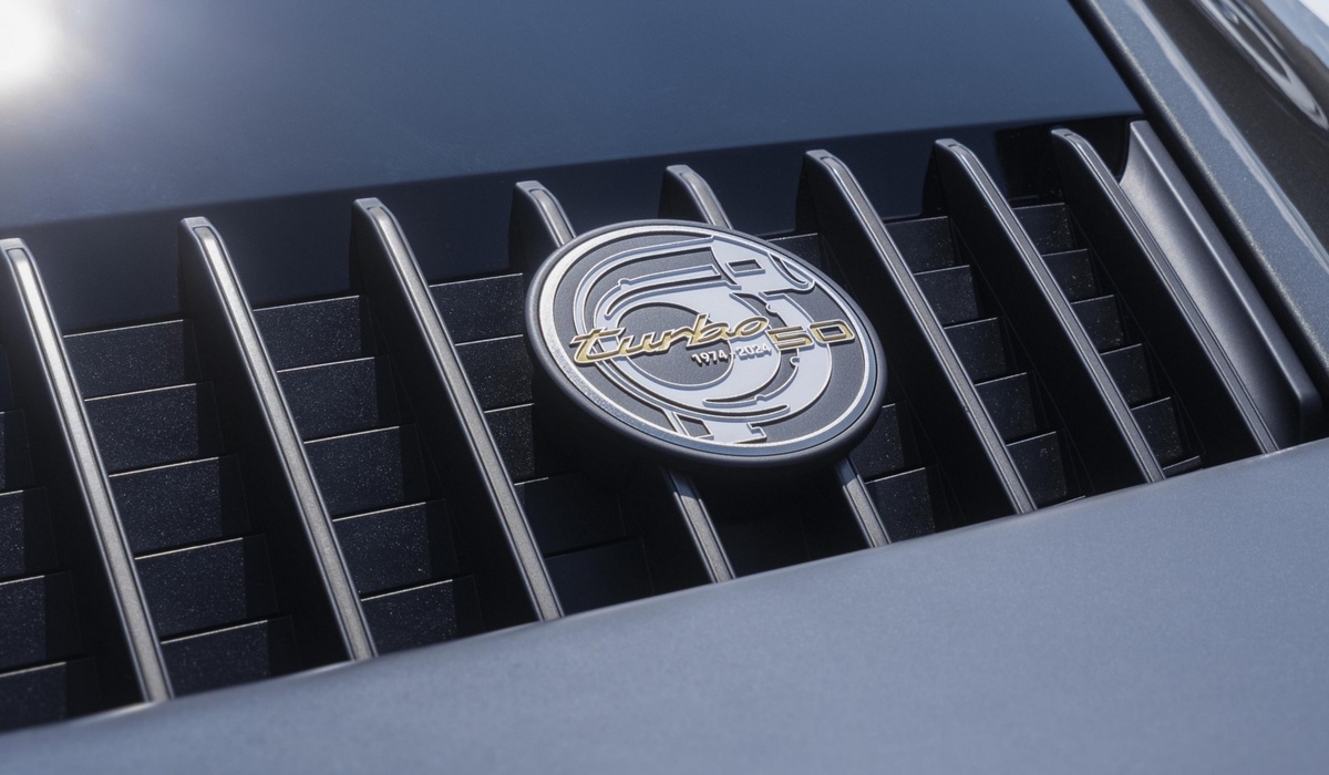 mid Groß-Gerau - Ein Badge auf dem Heckdeckelgitter zeigt ein Turbolader-Icon und die Jahreszahlen